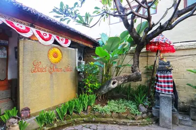 a sign for a restaurant with a tree in a garden at Hotel Sinar Bali Legian in Legian