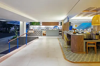 a restaurant with a counter and a bar at Kampi Hotel Legian in Legian