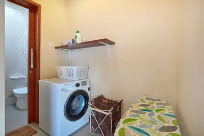 a laundry room with a washing machine and a toilet at Kae Villa Anggrek in Seminyak