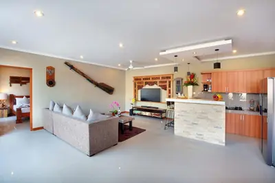 a kitchen and living room with a couch and a counter at Kae Villa Anggrek in Seminyak