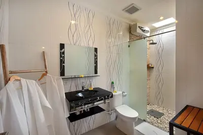 a bathroom with a toilet and a tv on the wall at Kae Villa Anggrek in Seminyak