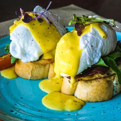 a plate of food with an egg on a sandwich at Daha Mansions Seminyak in Seminyak