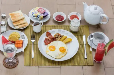 a table with a plate of eggs and breakfast foods at Entrada Seminyak Villa By Nagisa Bali in Seminyak