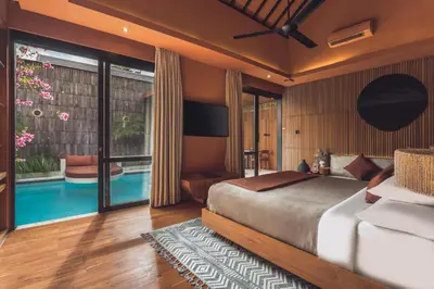 a bedroom with a bed and a swimming pool at Sana Vie Villa Seminyak by Ini Vie Hospitality in Seminyak