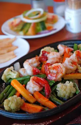 a tray of food with shrimp and vegetables on a table at Green Garden Hotel in Kuta
