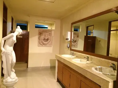 a bathroom with two sinks and a statue of a woman at Green Garden Hotel in Kuta