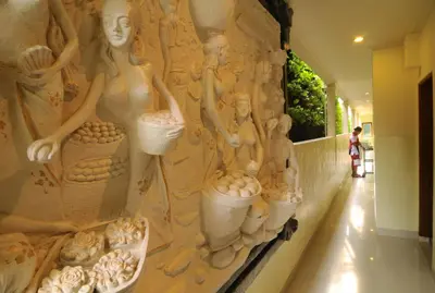 a wall with a mural of women holding eggs at Green Garden Hotel in Kuta