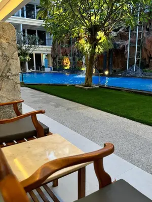 a table and chairs in front of a swimming pool at Green Garden Hotel in Kuta