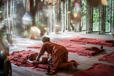 a man sitting on a bed with a woman on it at Balquisse Heritage Hotel in Jimbaran