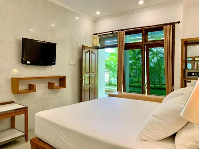 a bedroom with a bed and a tv on a wall at Febri's Hotel & Spa in Kuta