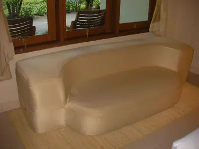 a couch sitting under a window in a room at Febri's Hotel & Spa in Kuta