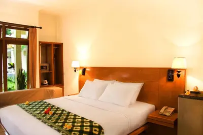 a hotel room with a bed and a telephone at Febri's Hotel & Spa in Kuta
