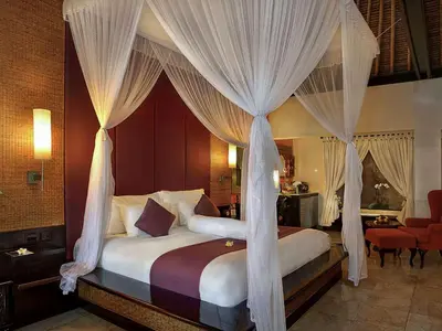 a bedroom with a canopy bed with curtains at The Royal Beach Seminyak Bali in Seminyak