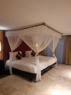 a bedroom with a white bed with a canopy at The Royal Beach Seminyak Bali in Seminyak