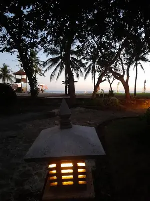 a lighted altar in front of the beach at night at The Royal Beach Seminyak Bali in Seminyak