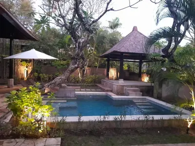 a swimming pool with a gazebo in a yard at The Royal Beach Seminyak Bali in Seminyak