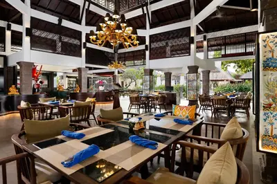 a restaurant with tables and chairs and a chandelier at Rama Beach Resort and Villas in Kuta
