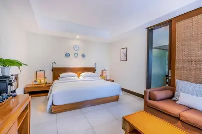 a bedroom with a bed and a couch at Rama Garden Hotel Bali in Legian