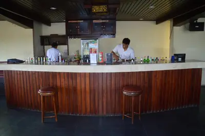 a man standing at a bar in a restaurant at Champlung Mas Hotel Legian in Legian