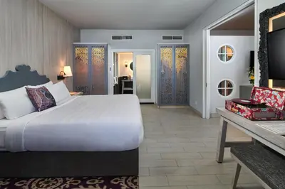 a bedroom with a large white bed and a desk at Hard Rock Hotel Bali in Kuta