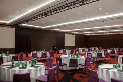 a banquet hall with white tables and purple chairs at Hard Rock Hotel Bali in Kuta