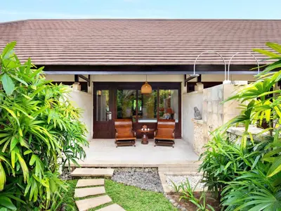 a house with a patio with chairs and a table at Novotel Bali Benoa in Nusa Dua