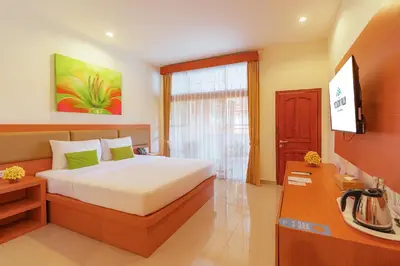 a bedroom with a bed and a television in it at Wina Holiday Villa Kuta Bali in Kuta
