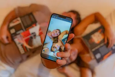 a man holding a cell phone in his hand at Wina Holiday Villa Kuta Bali in Kuta