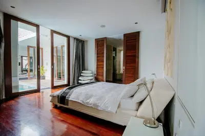 a bedroom with a large bed and a mirror at C151 Smart Villas at Seminyak in Seminyak