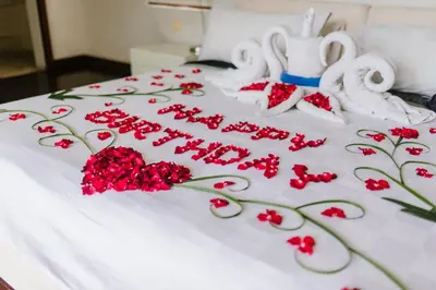 a white bed with red flowers and white towels at C151 Smart Villas at Seminyak in Seminyak
