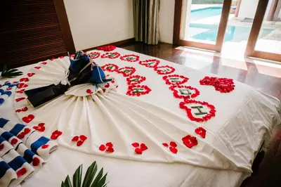 a large white cake with red flowers on a bed at C151 Smart Villas at Seminyak in Seminyak