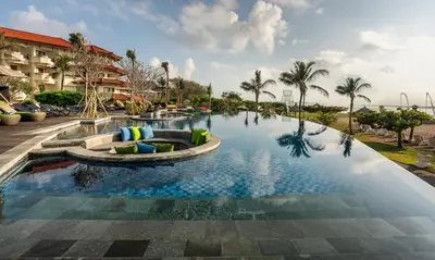 a pool at a resort with palm trees at Grand Mirage Resort & Thalasso Bali in Nusa Dua