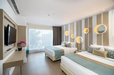 a hotel room with two beds and a television at Grand Mirage Resort & Thalasso Bali in Nusa Dua