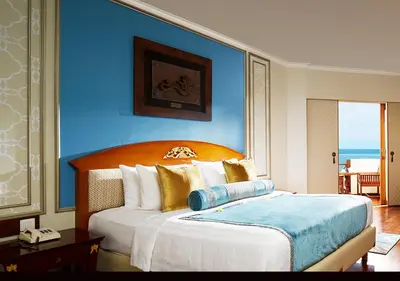 a bedroom with a large bed with a blue wall at Grand Mirage Resort & Thalasso Bali in Nusa Dua