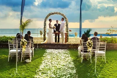 a wedding ceremony on the beach with a bride and groom at The Oberoi Beach Resort, Bali in Seminyak