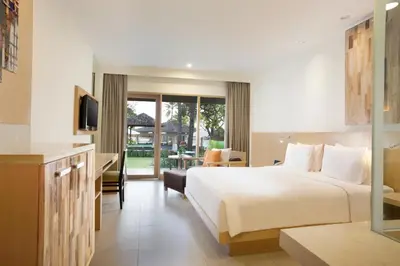 a hotel room with a bed and a television at Holiday Inn Resort Baruna Bali by IHG in Kuta
