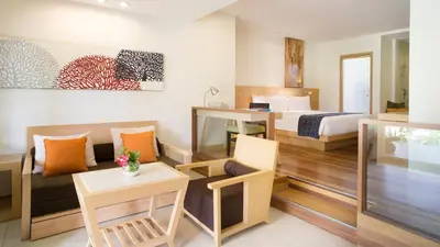 a hotel room with a king bed and a desk at Holiday Inn Resort Baruna Bali by IHG in Kuta