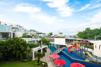 an apartment complex with a pool and a water slide at FuramaXclusive Ocean Beach Seminyak Bali in Legian