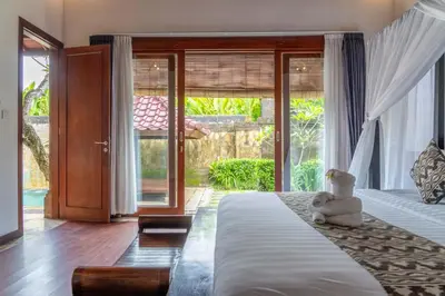 a bedroom with a bed with a teddy bear sitting on it at Bali Prime Villas Seminyak by Kanaya Hospitality in Seminyak