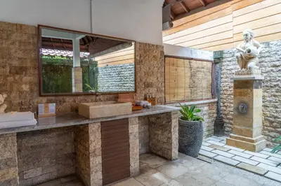 a bathroom with a stone counter and a statue at Bali Prime Villas Seminyak by Kanaya Hospitality in Seminyak