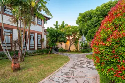 a walkway in front of a house with flowers at Desamuda Village by Pertama Management in Seminyak