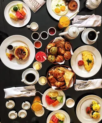 a table filled with plates of breakfast foods and drinks at The Elysian Boutique Villa Hotel in Seminyak