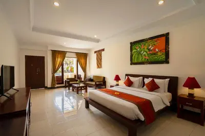 a bedroom with a large bed and a living room at Kusuma Resort Seminyak in Seminyak