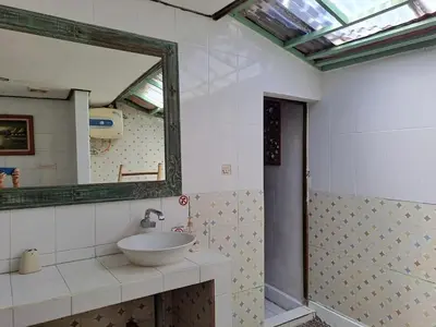 a bathroom with a sink and a mirror at Shalana Homestay- formerly Teka Teki House in Seminyak