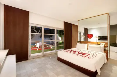 a bedroom with a large bed and a large mirror at Uma Sapna Seminyak in Seminyak