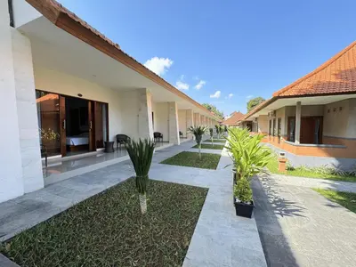 a courtyard of a house with palm trees at New Garden View Resort in Legian
