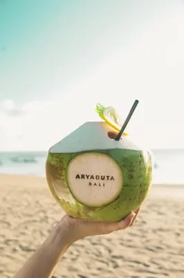 a person holding an avocado on the beach at Aryaduta Bali in Kuta