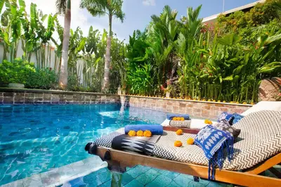 a pool with a chaise lounge with fruit on it at Villa Besok in Seminyak