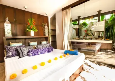 a bedroom with a large bed with colorful pillows at Villa Besok in Seminyak