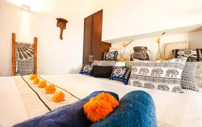 a bedroom with two beds with orange and blue pillows at Villa Besok in Seminyak